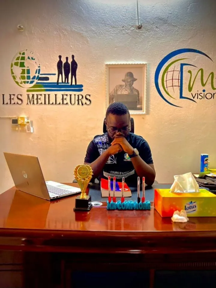Un encadreur à son bureau, trophées devant lui